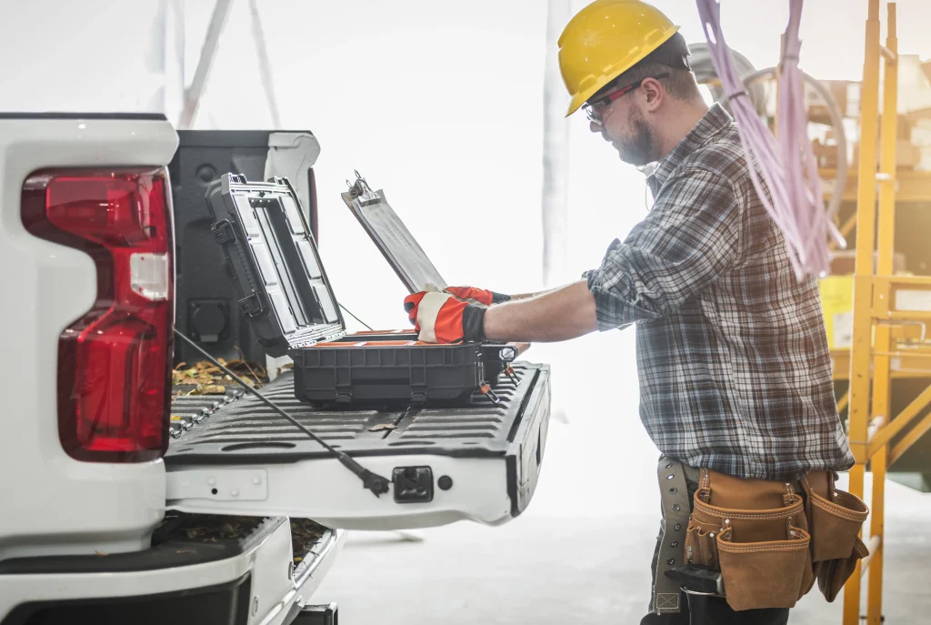 Worker with hard hat using toolkit on truck