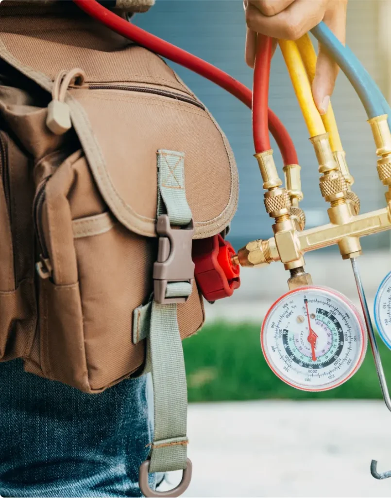 Technician holding a HVAC manifold gauge.