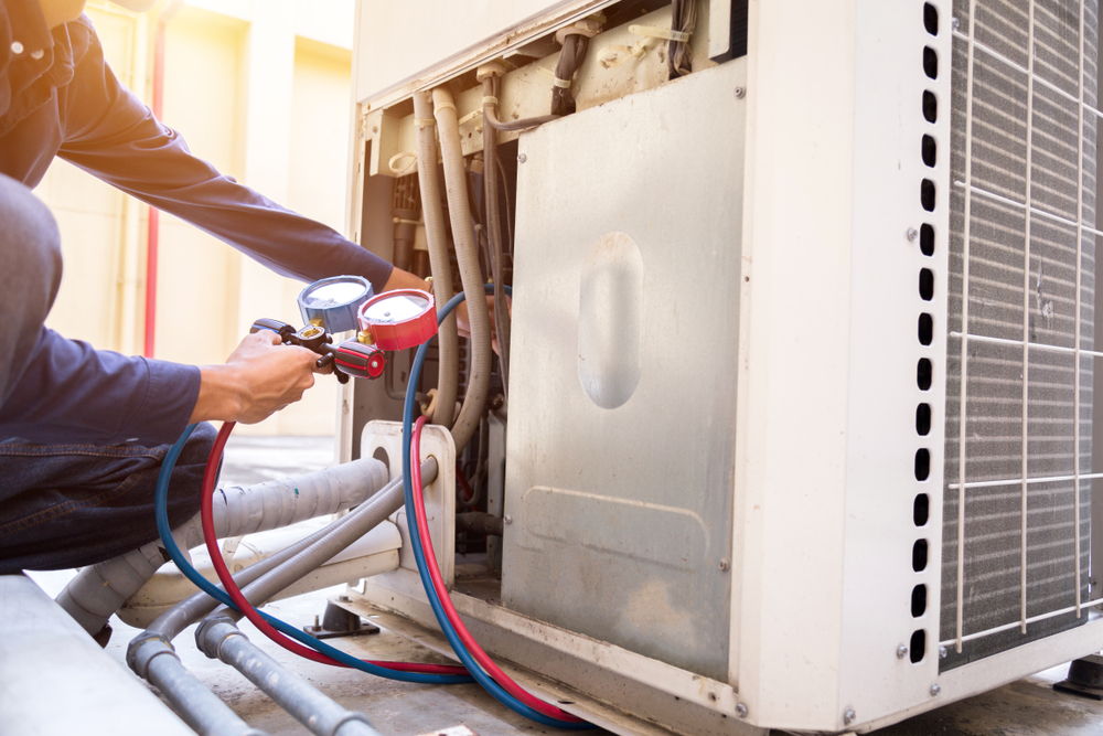 Technician inspecting air conditioning unit.