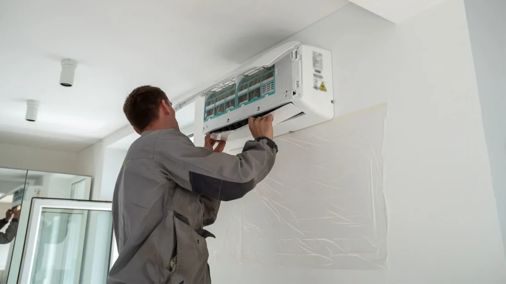 An HVAC technician fixing an air conditioning system inside a property