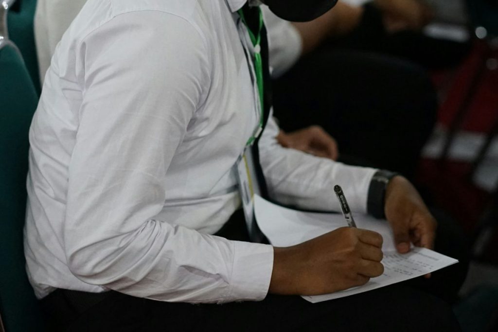 a man writing on a piece of paper