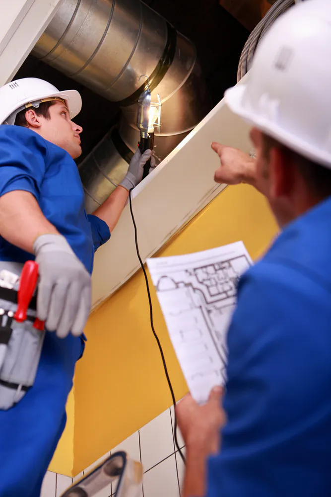 HVAC Contractors inspecting ventilation system.